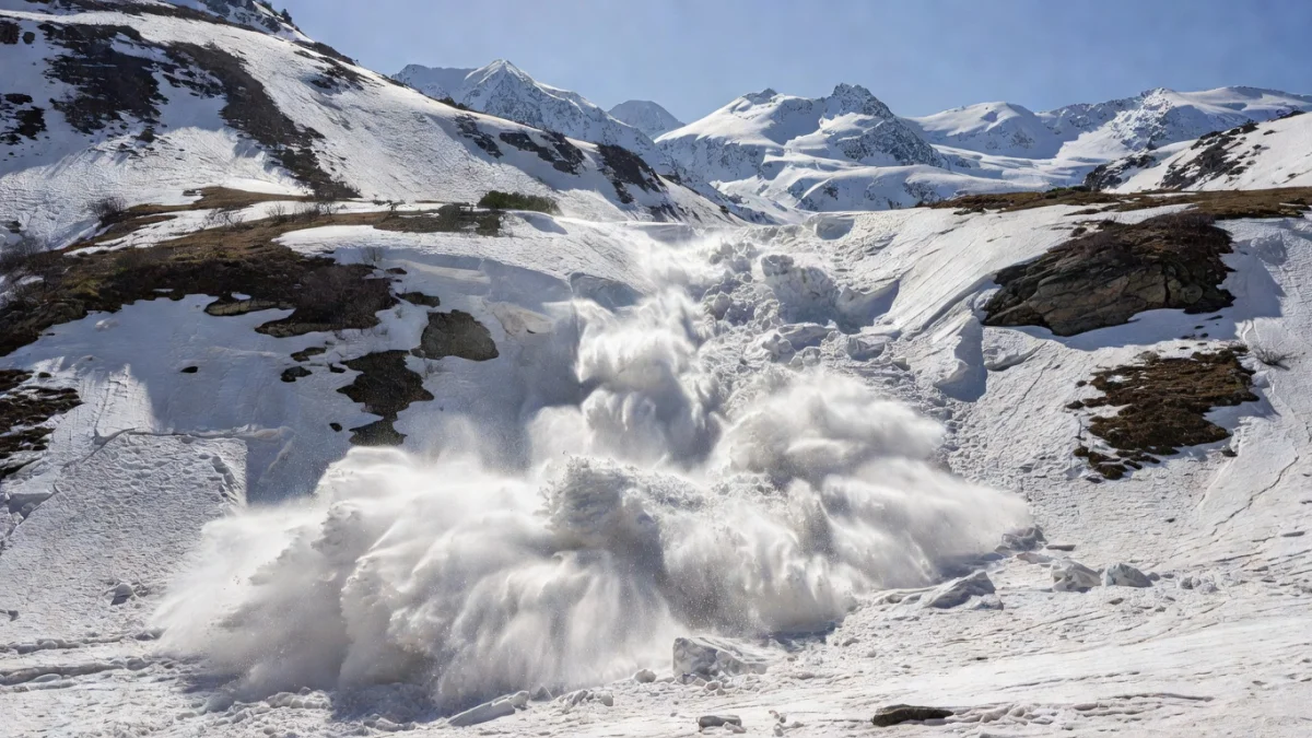 Avalanche dévalant un versant enneigé au printemps dans les Alpes