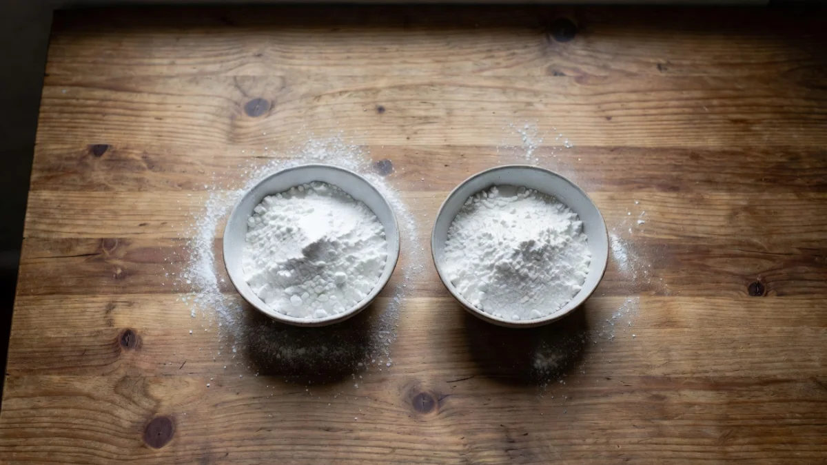 Bicarbonate alimentaire et levure chimique côte à côte sur un plan de travail de cuisine